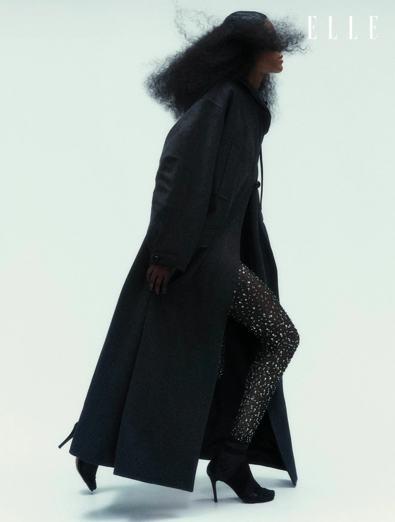 Modellen har på sig en svart kappa och byxor med strass, båda från Isabel Marant