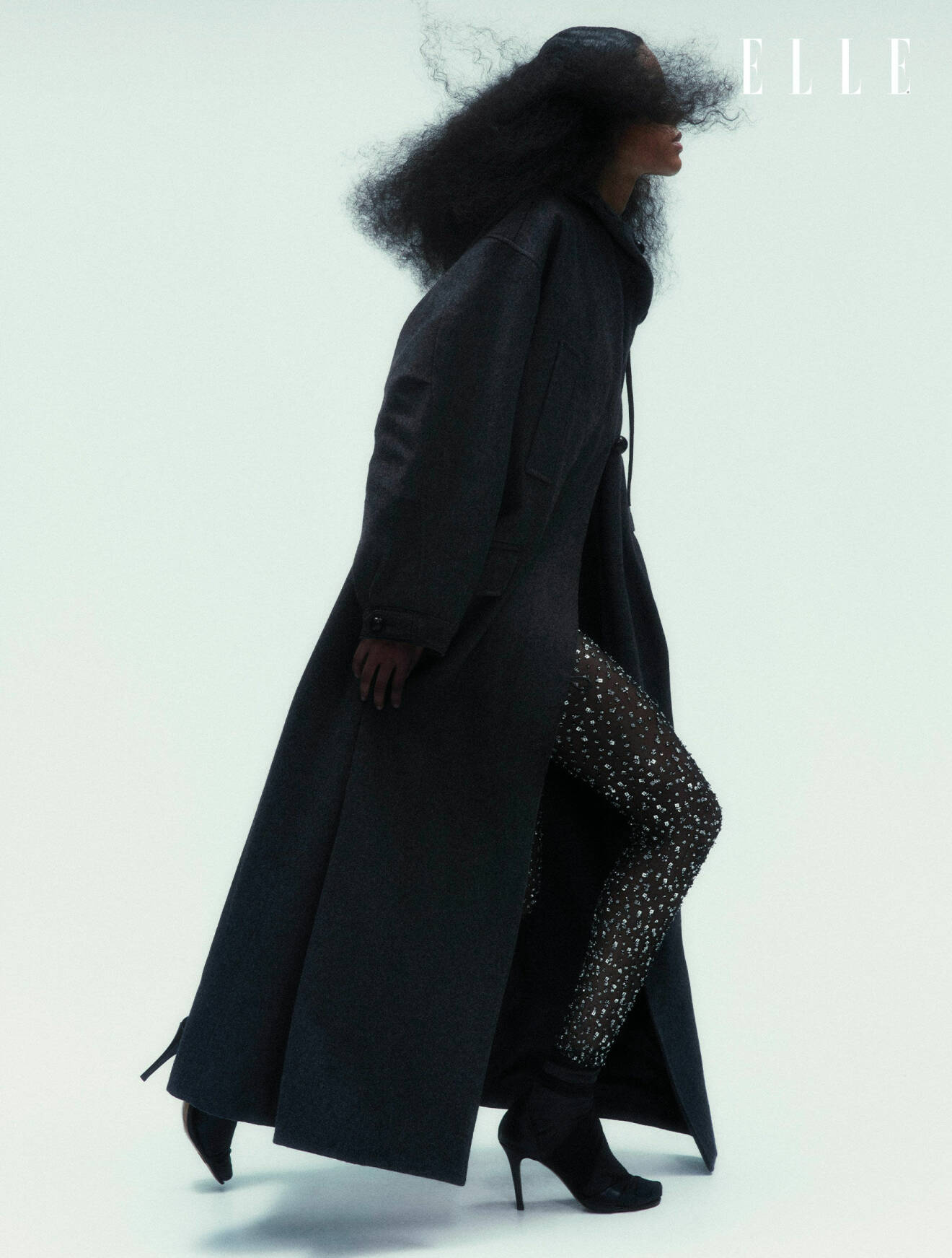 Modellen har på sig en svart kappa och byxor med strass, båda från Isabel Marant