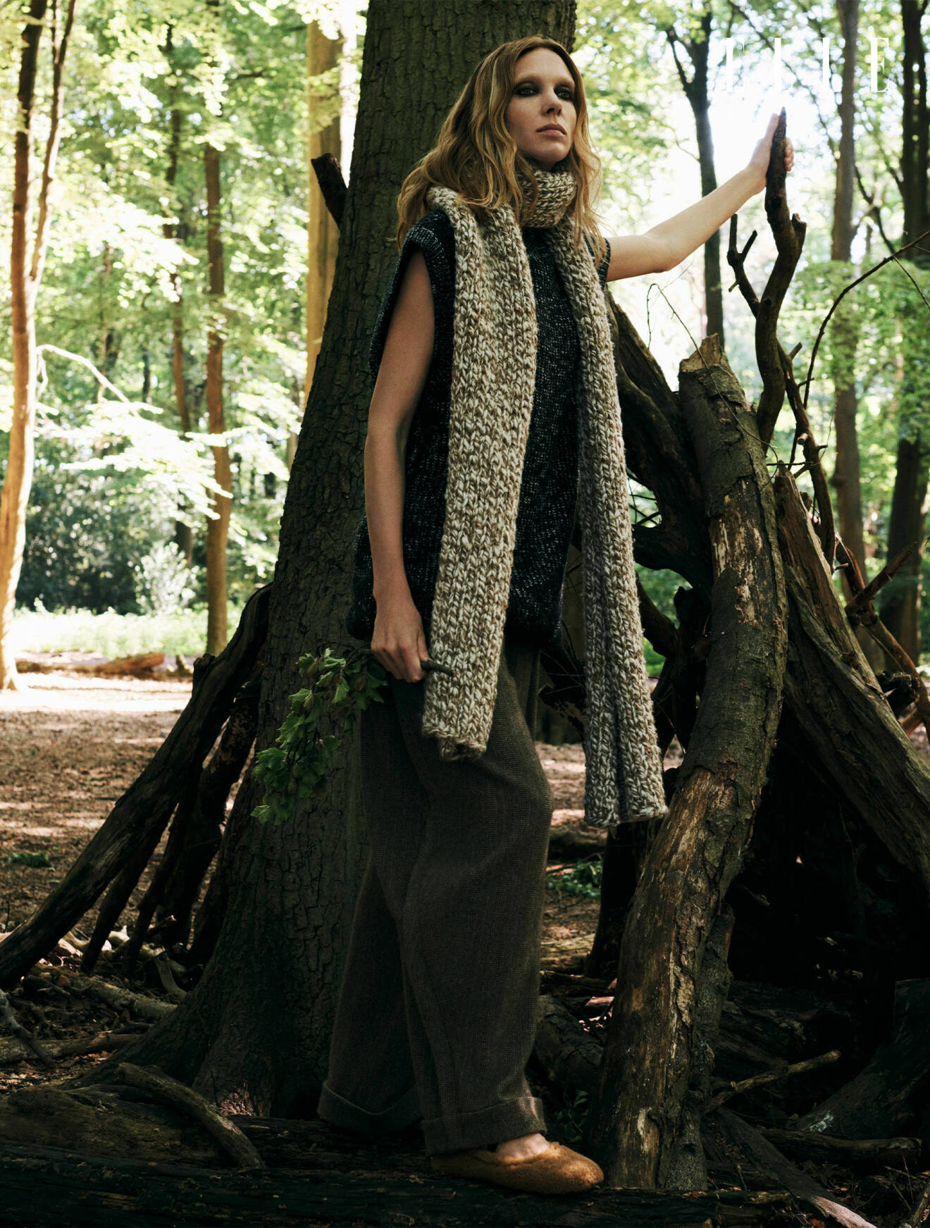Fotomodellen har på sig en stickad tröja, byxor och en lång stickad scarf, allt från Louis Vuitton