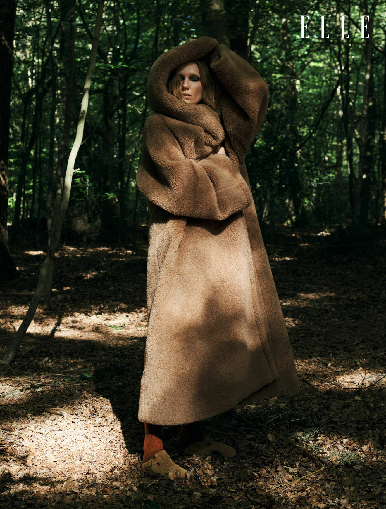 Modellen har på sig en brun fuskpälskappa med stor luva, från Max Mara