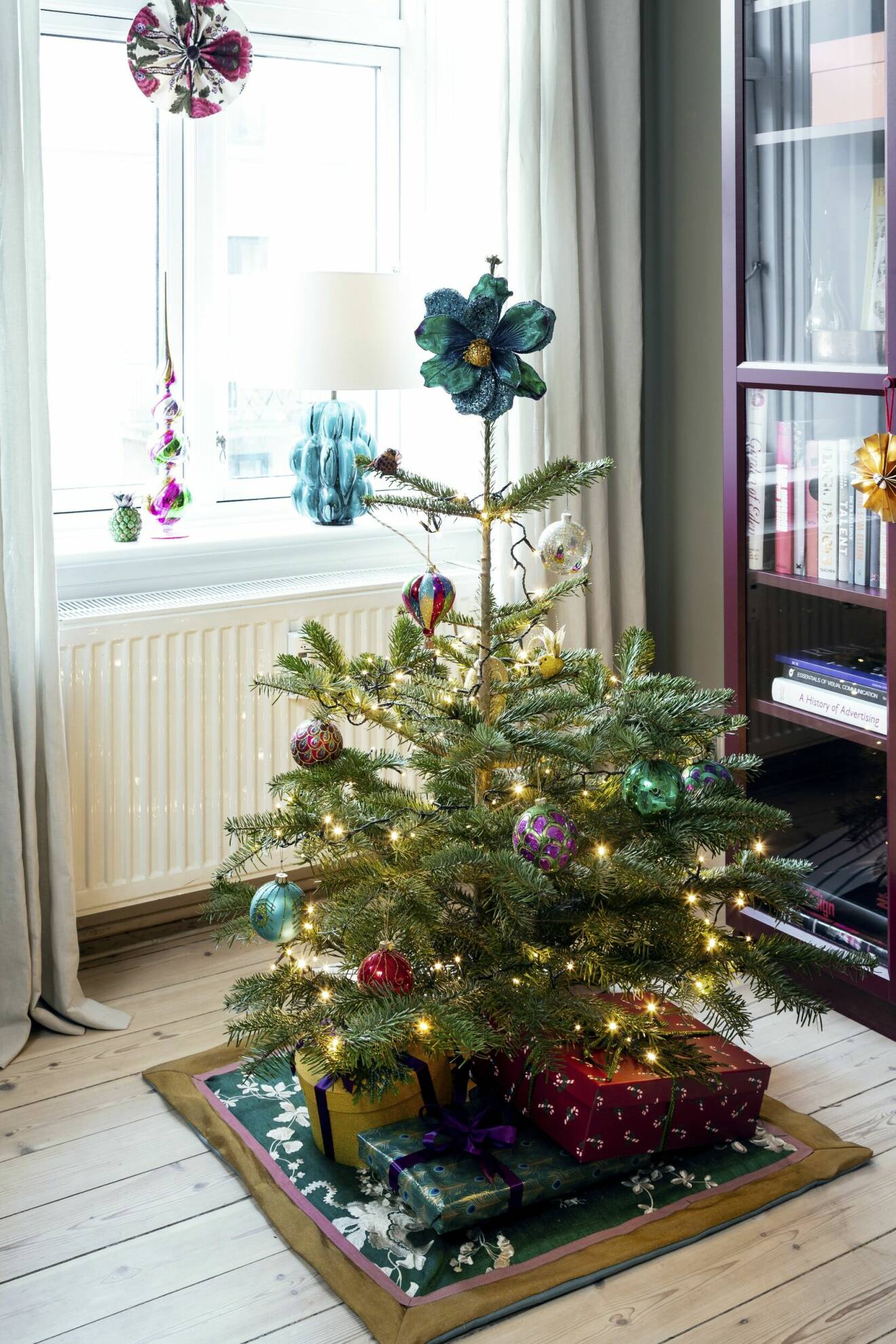 Liten julgran på hemmasydd julgransmatta med velourblomma som julgransstjärna
