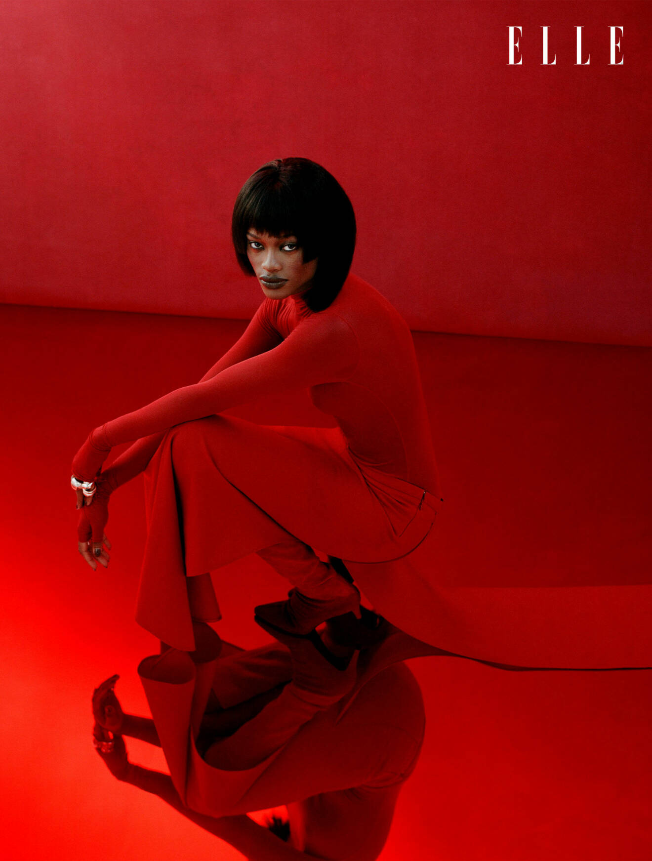 Modellen bär en röd catsuit med en röd kjol, båda från Courrèges