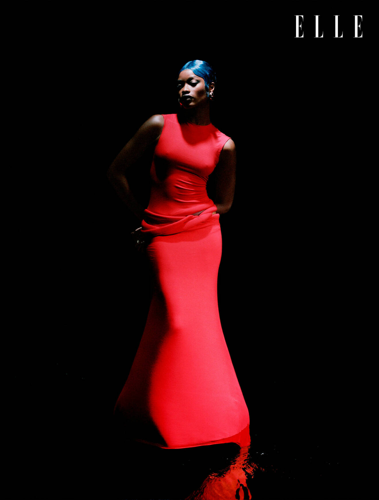 Modellen har på sig en lång röd klänning från Standing Ground