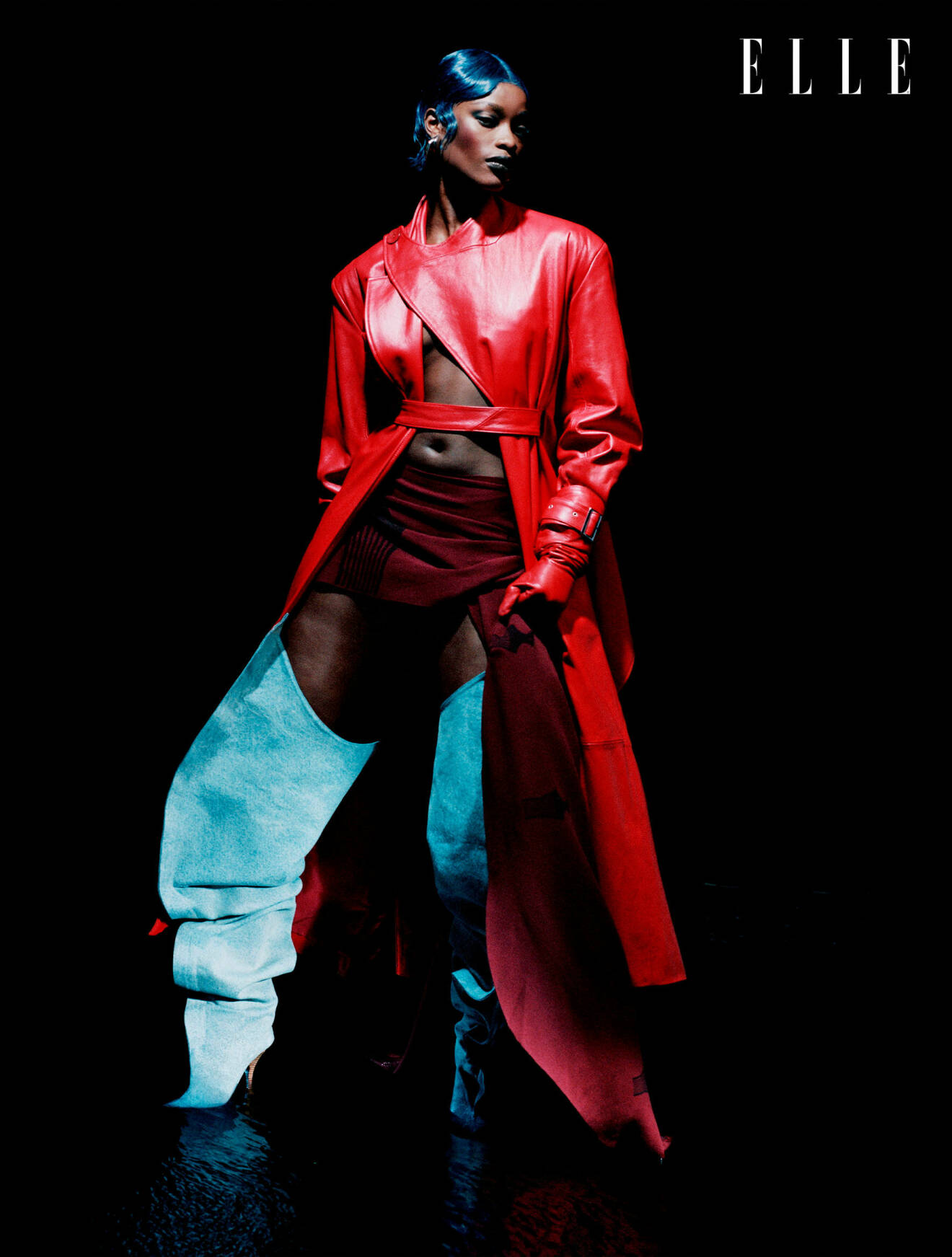Fotomodellen har p sig en lång röd kappa och röd kjol, båda från Selasi, samt röda handskar från Handsome Stockholm och boots från Y/project