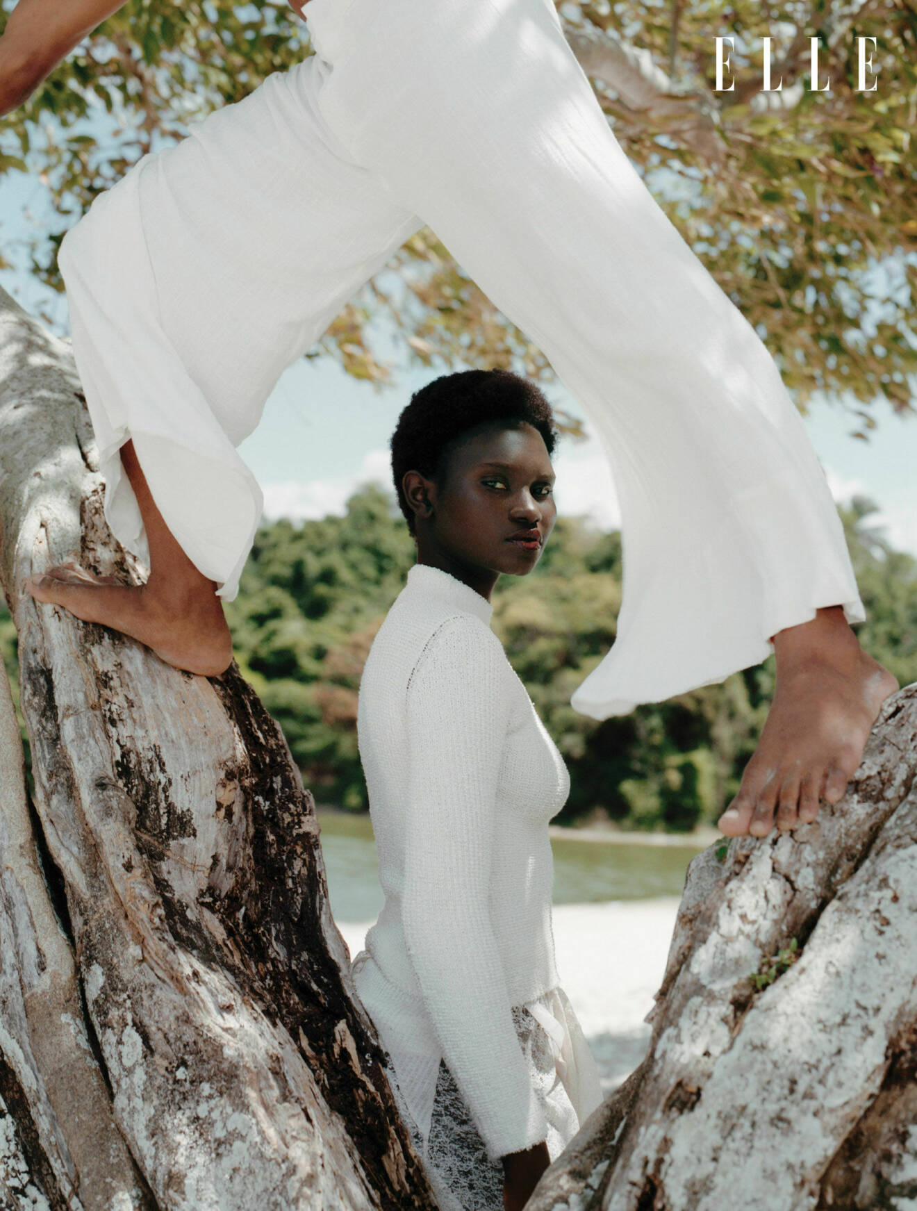Modellen står vid ett träd, klädd i en vit blus och kjol från Fendi
