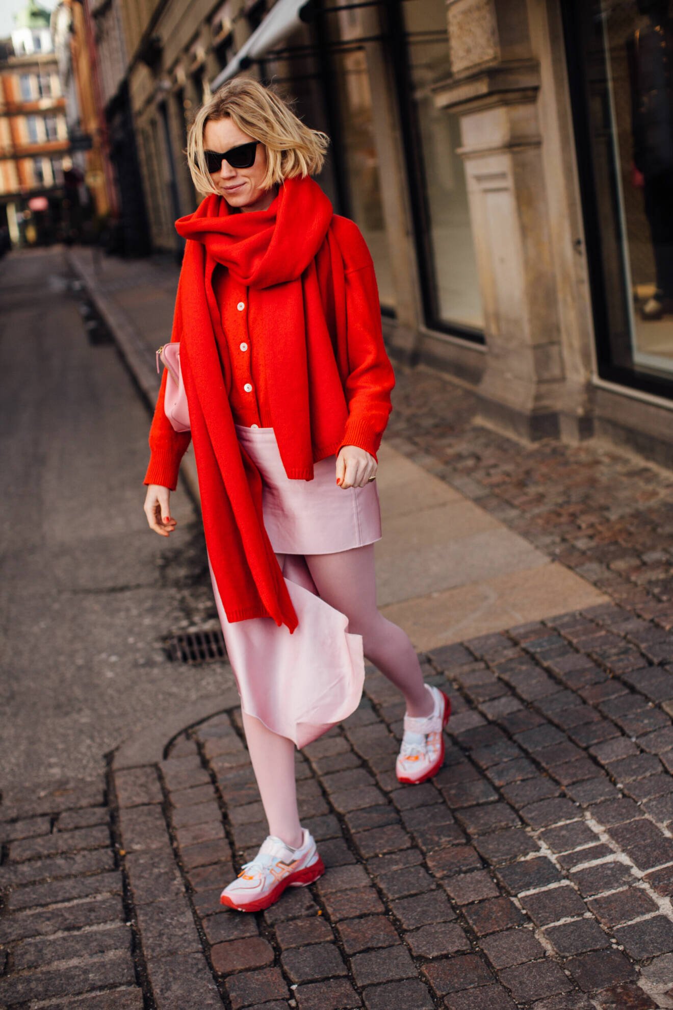 Streetstyle med rosa sneakers, rosa kjol pch röd kofta.