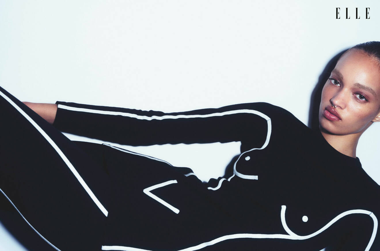 Modellen ligger ner, hon har på sig en svart topp med vita detaljer med matchande legging, båda från Moschino
