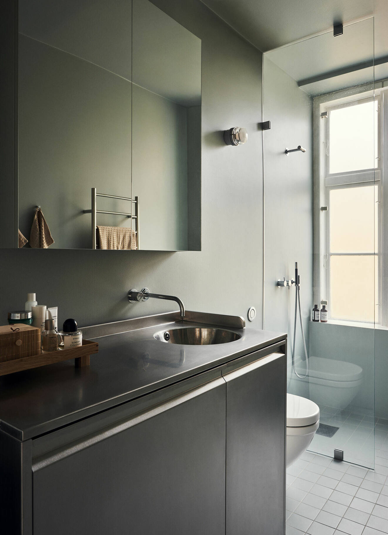 Det borstade rostfria stålet återkommer i kök och badrum. Arkitekt Johannes Norlander ombads fånga färgskalan från 1800-talskonstnären Vilhelm Hammershøi.