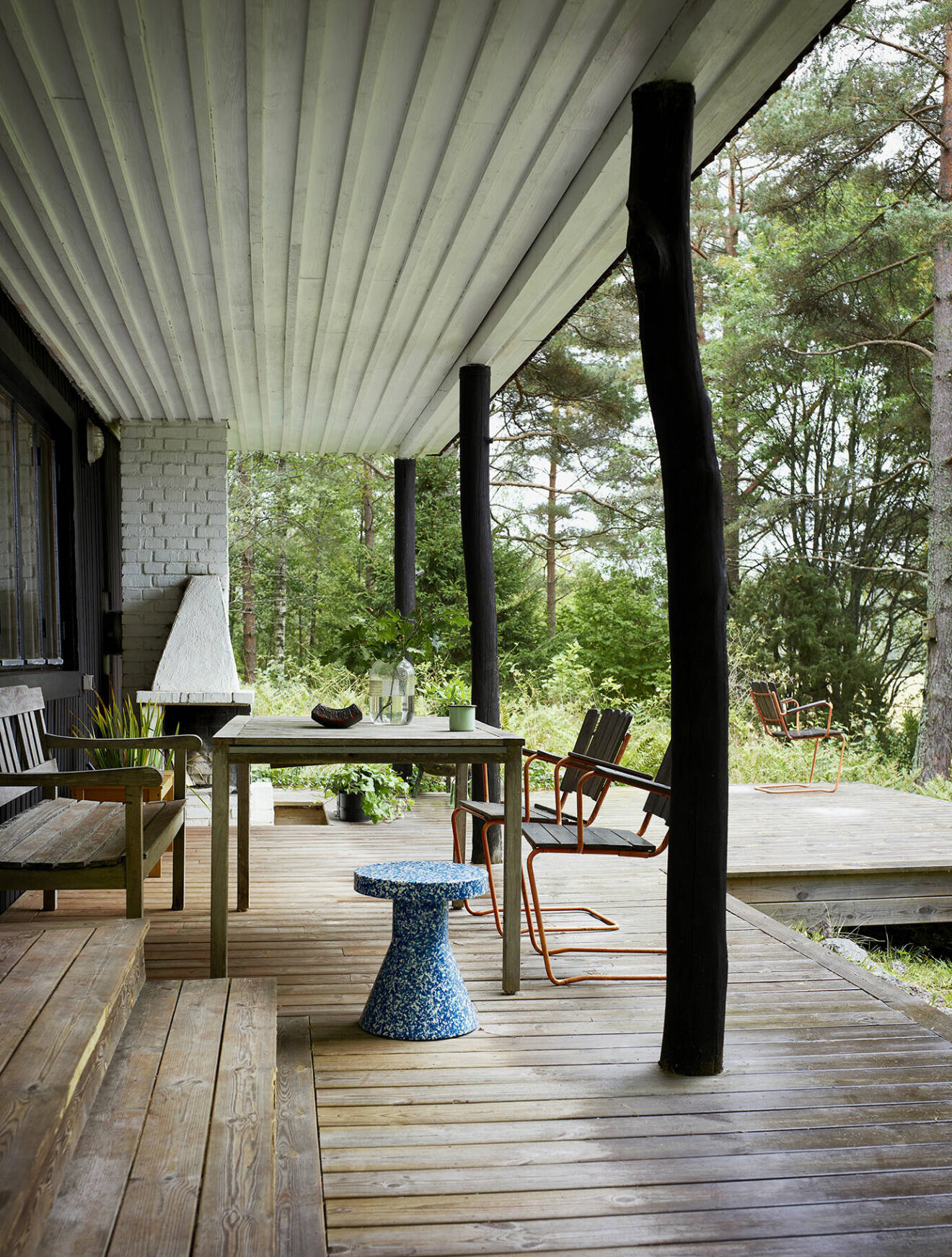 Det utdragna taket skapar en naturlig plats modellerad efter en veranda i den amerikanska södern. Den murade spisen används flitigt. Spräcklig pall, Normann Copenhagen.