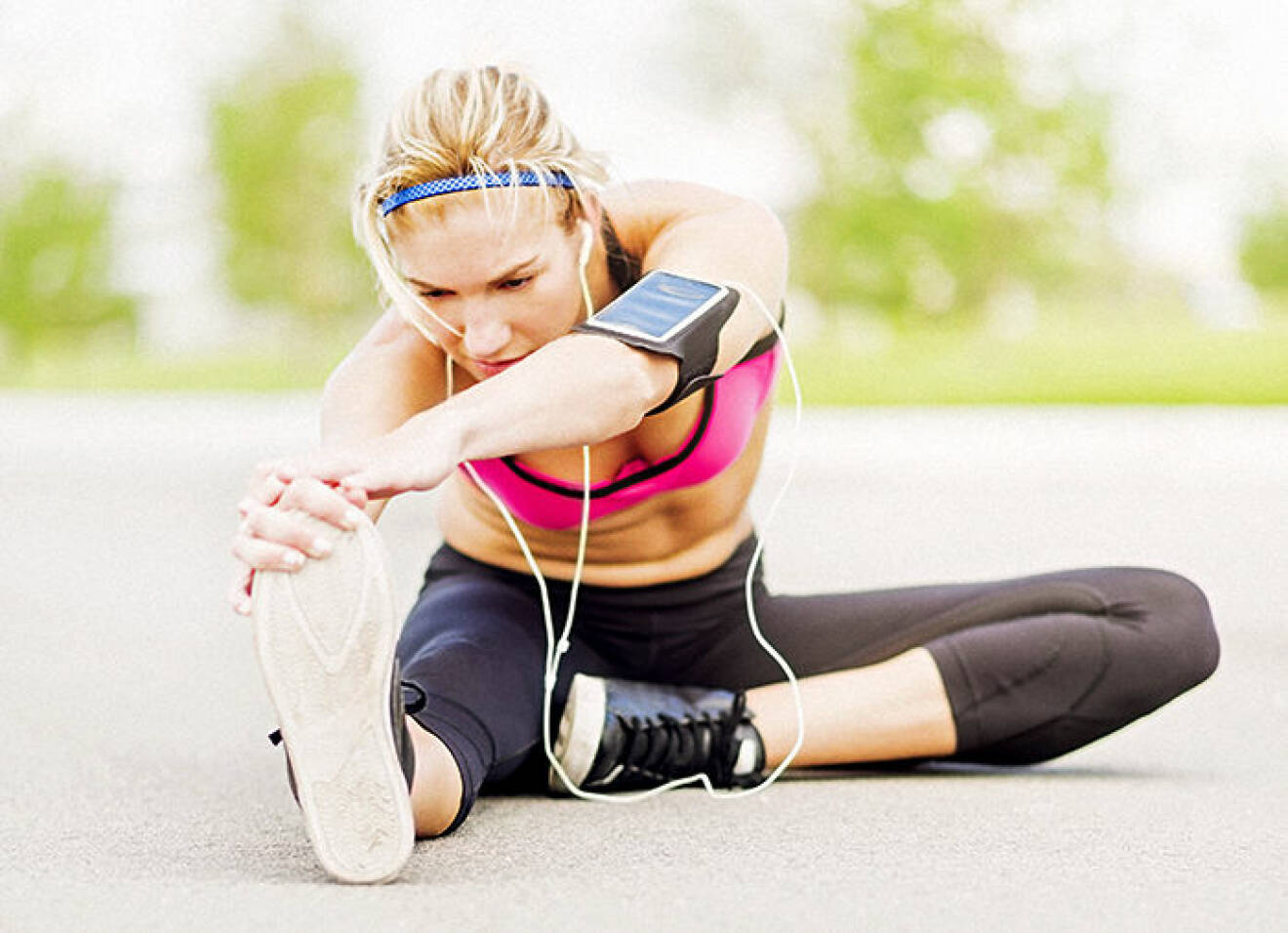 Young woman listening to music while stretching