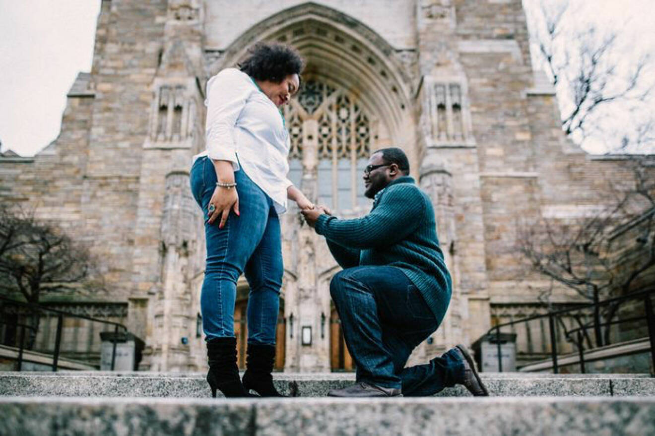 Man och fru förlovar sig framför en kyrka.