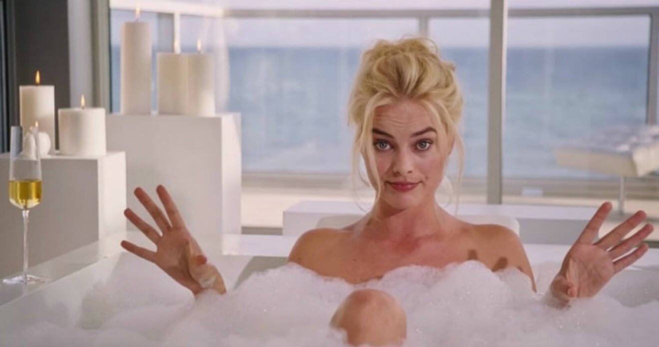 Kvinna i ett badkar med ett glas bubbel