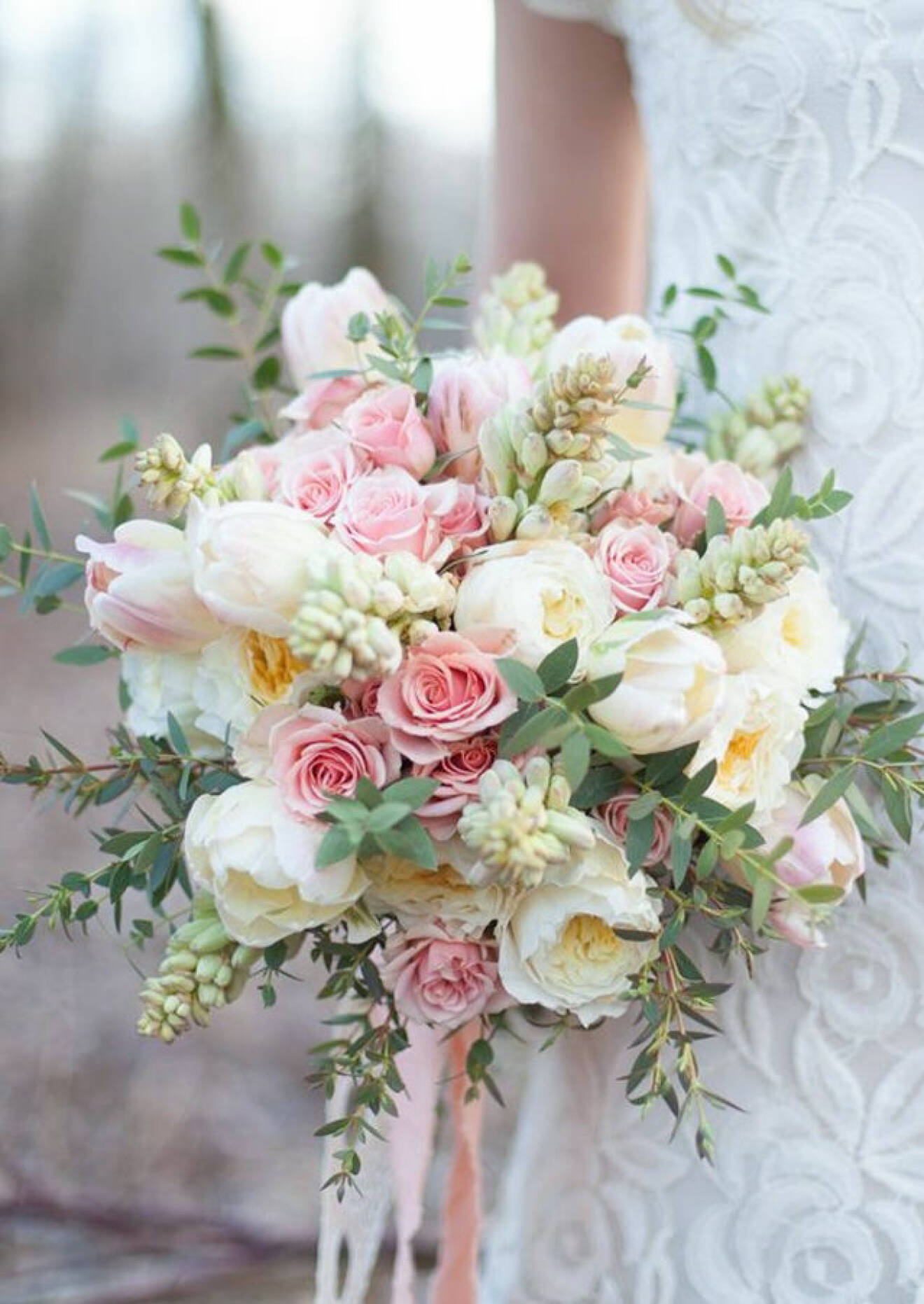 Rosa och vita blommor i brudbuketten. 