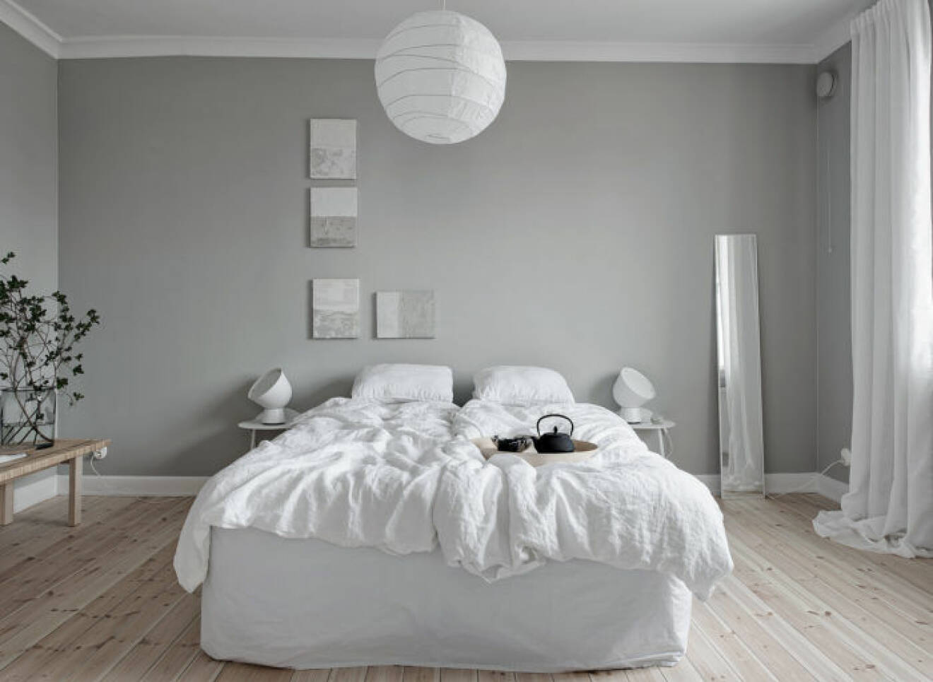 Sovrum med ljusgrå målade väggar.
