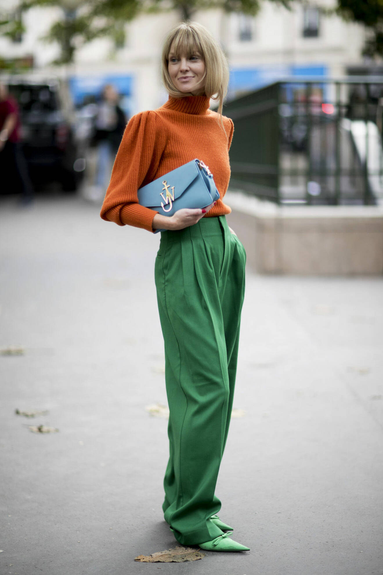 Jeanette Madsen i orange tröja och gröna byxor på Paris Fashion Week 2017