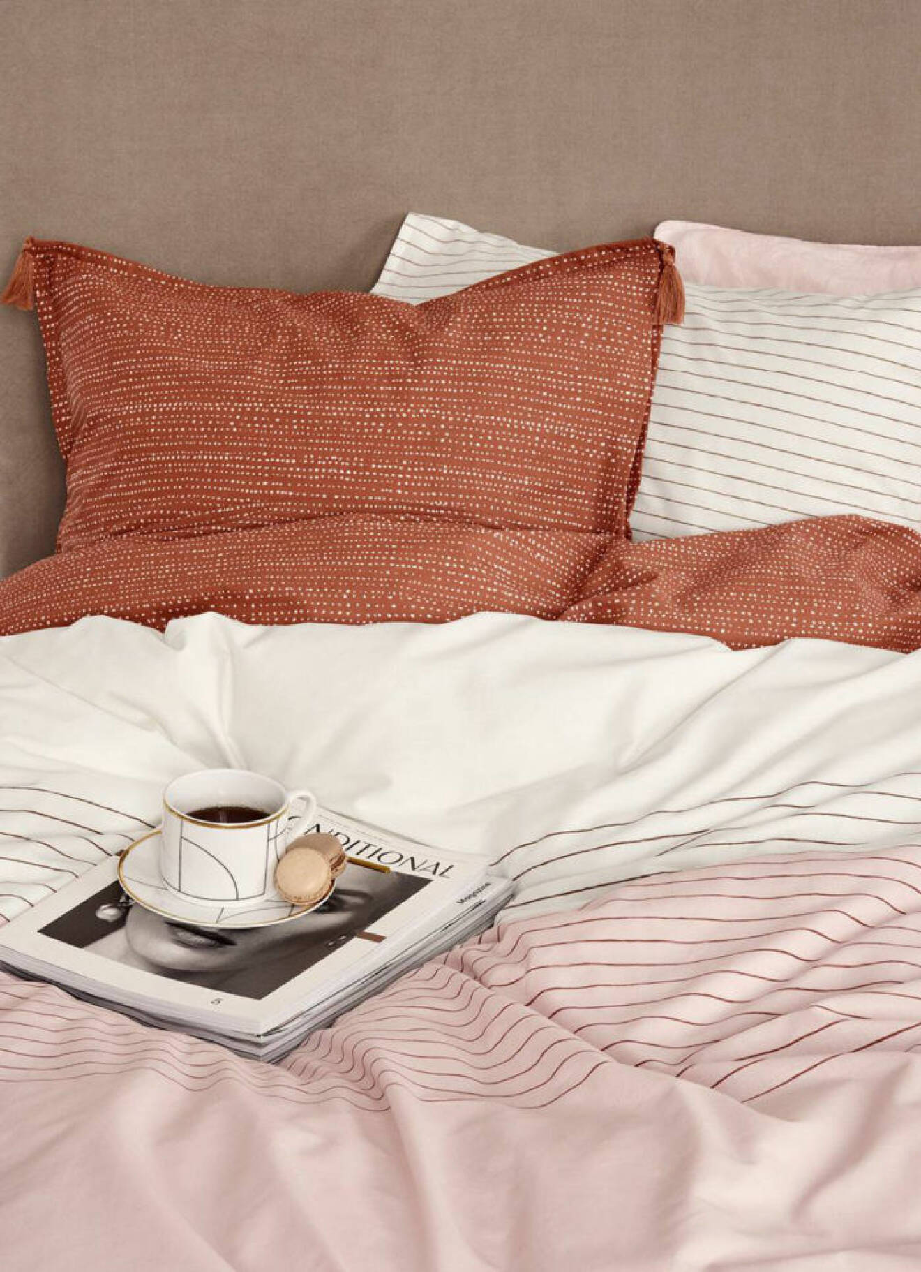 Närbild på säng med rosa och roströda sängkläder. H&M Home våren 2018. 