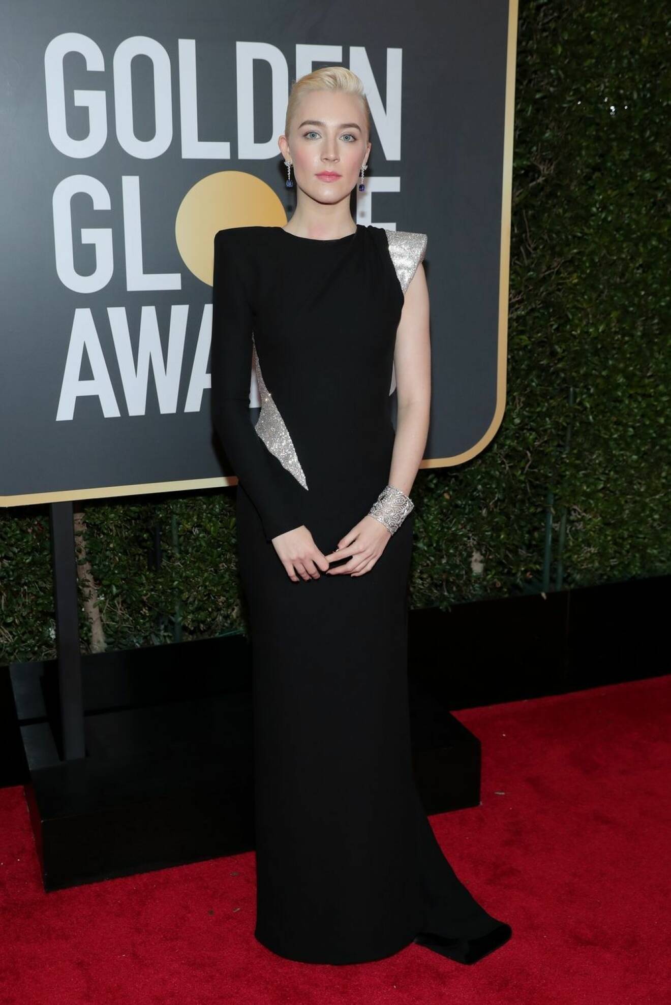 Saoirse Ronan bär en svart långklänning med skimrande silver detaljer.