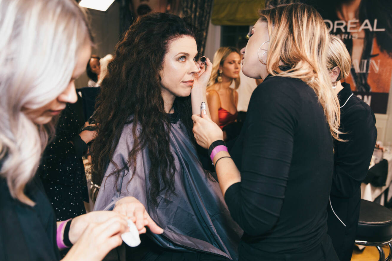 Backstage Elle-galan 2018, makeup appliceras på modell med lång hår.