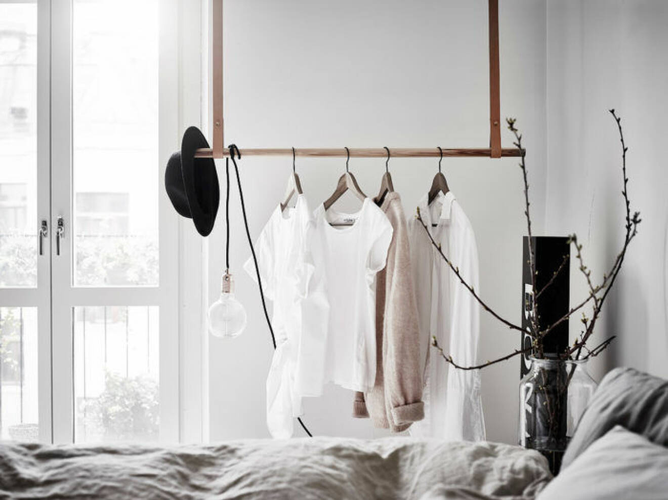 Cosy bedroom with hangers and leather handles. Scandinavian style. 