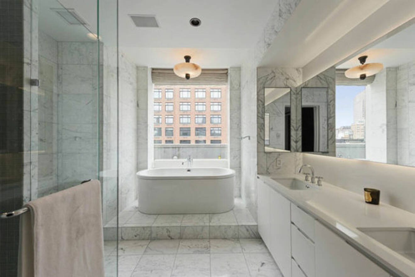 Stort badrum med marmor och badkar.