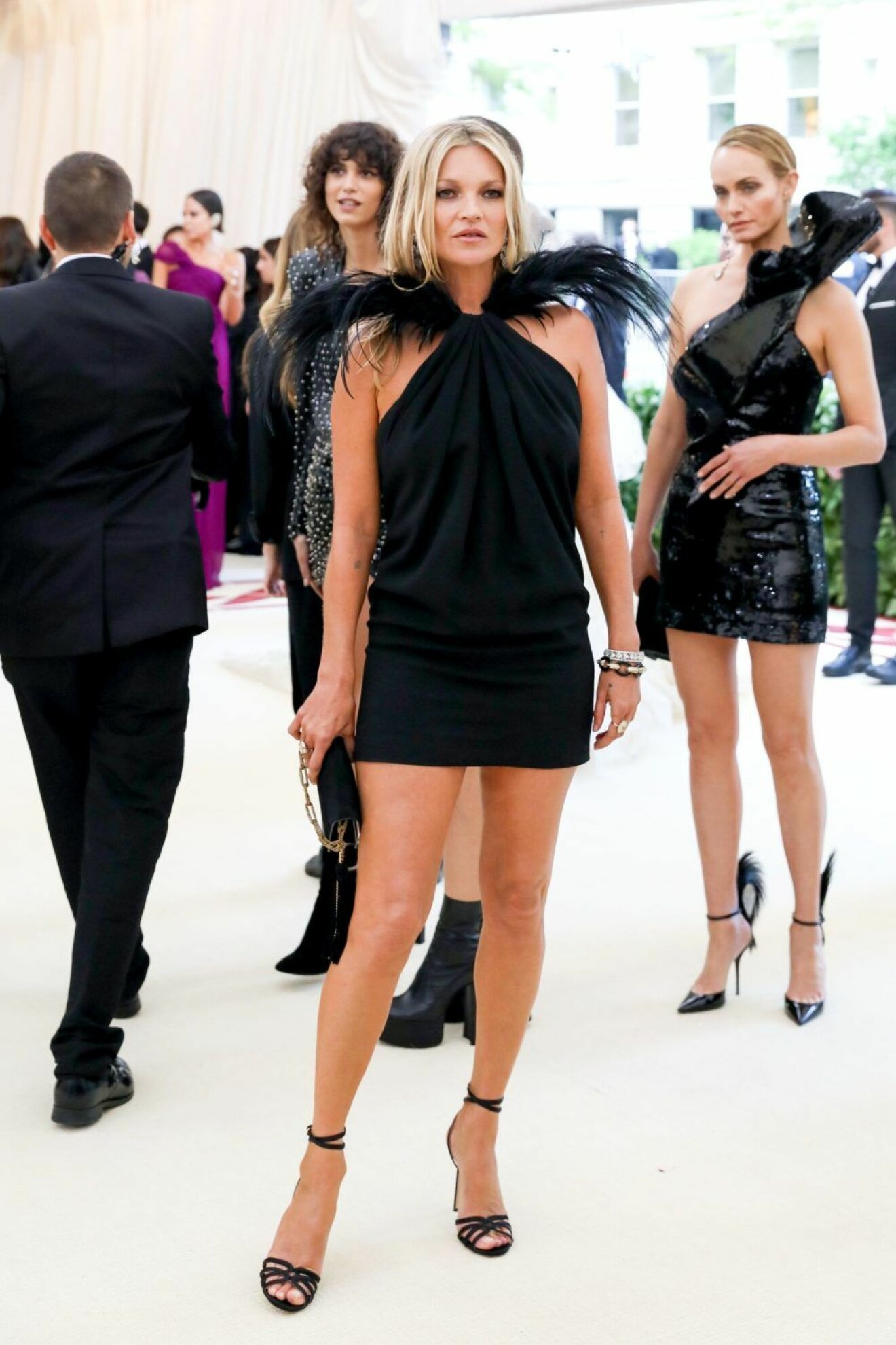 Kate Moss i kort svart klänning med fjäderdetaljer.