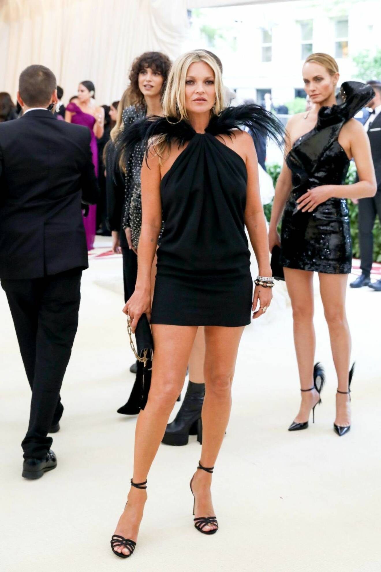 Kate Moss i kort svart klänning med fjäderdetaljer.