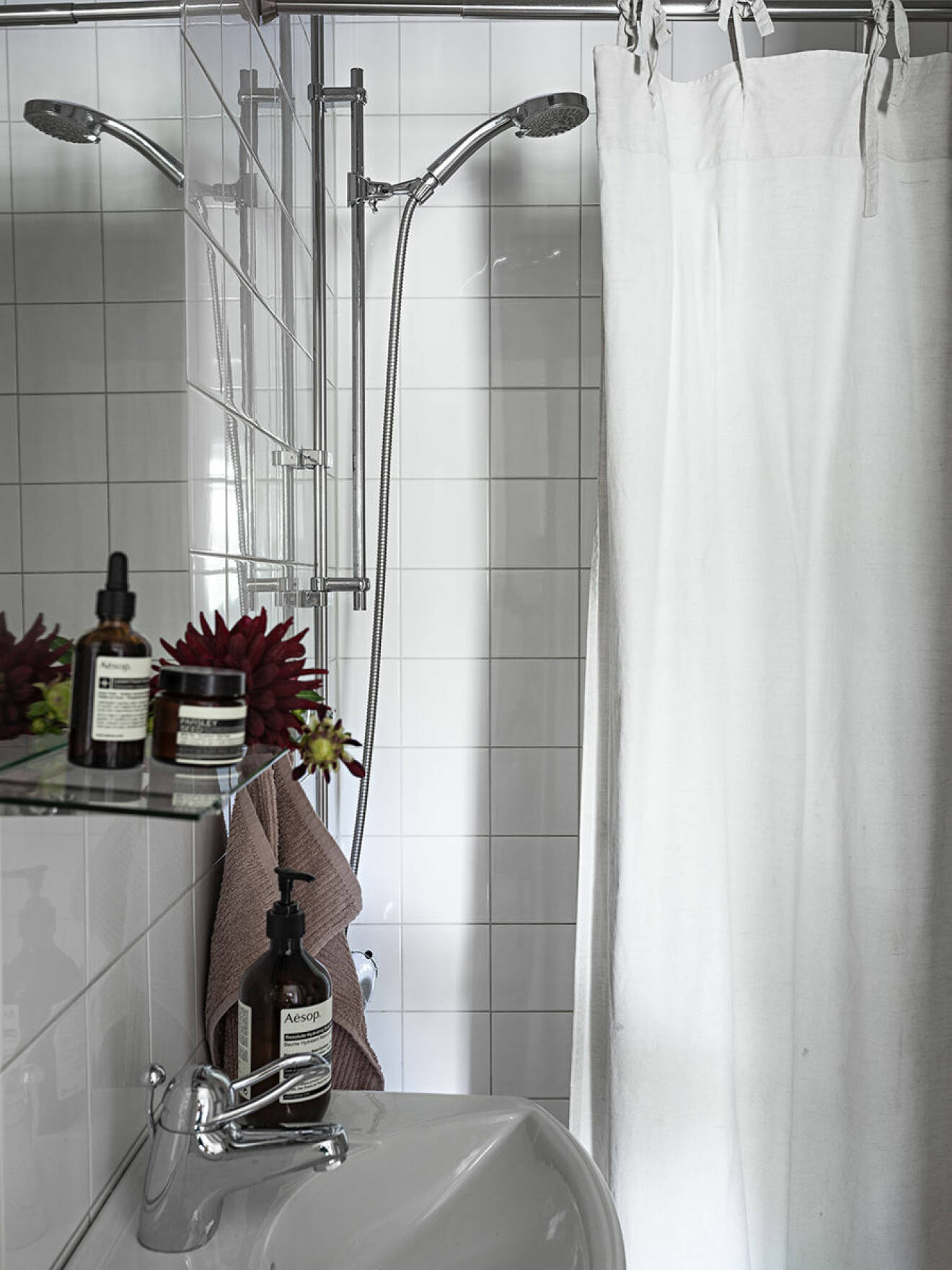 Badrum med tvålar, krämer, duschdraperi.