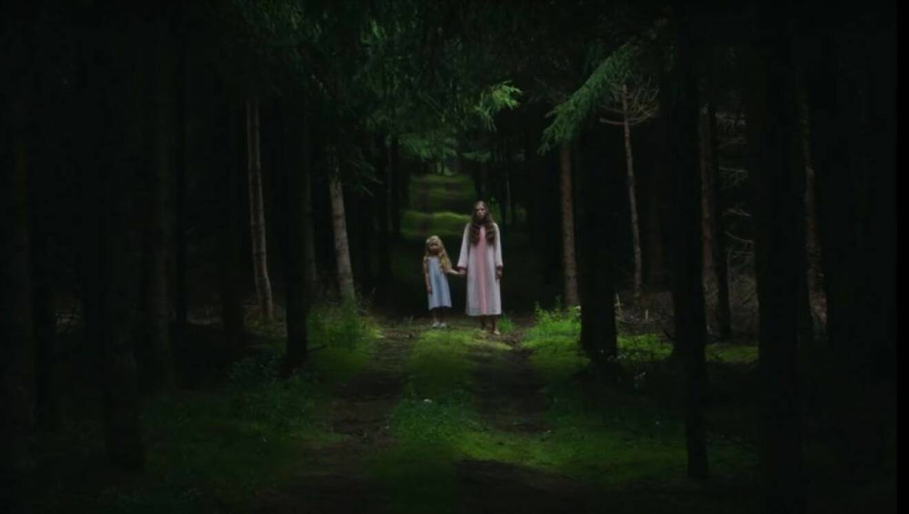 Två flickor står i en mörk skog och håller handen i zombiefilmen Les Affamés som finns på Netflix.