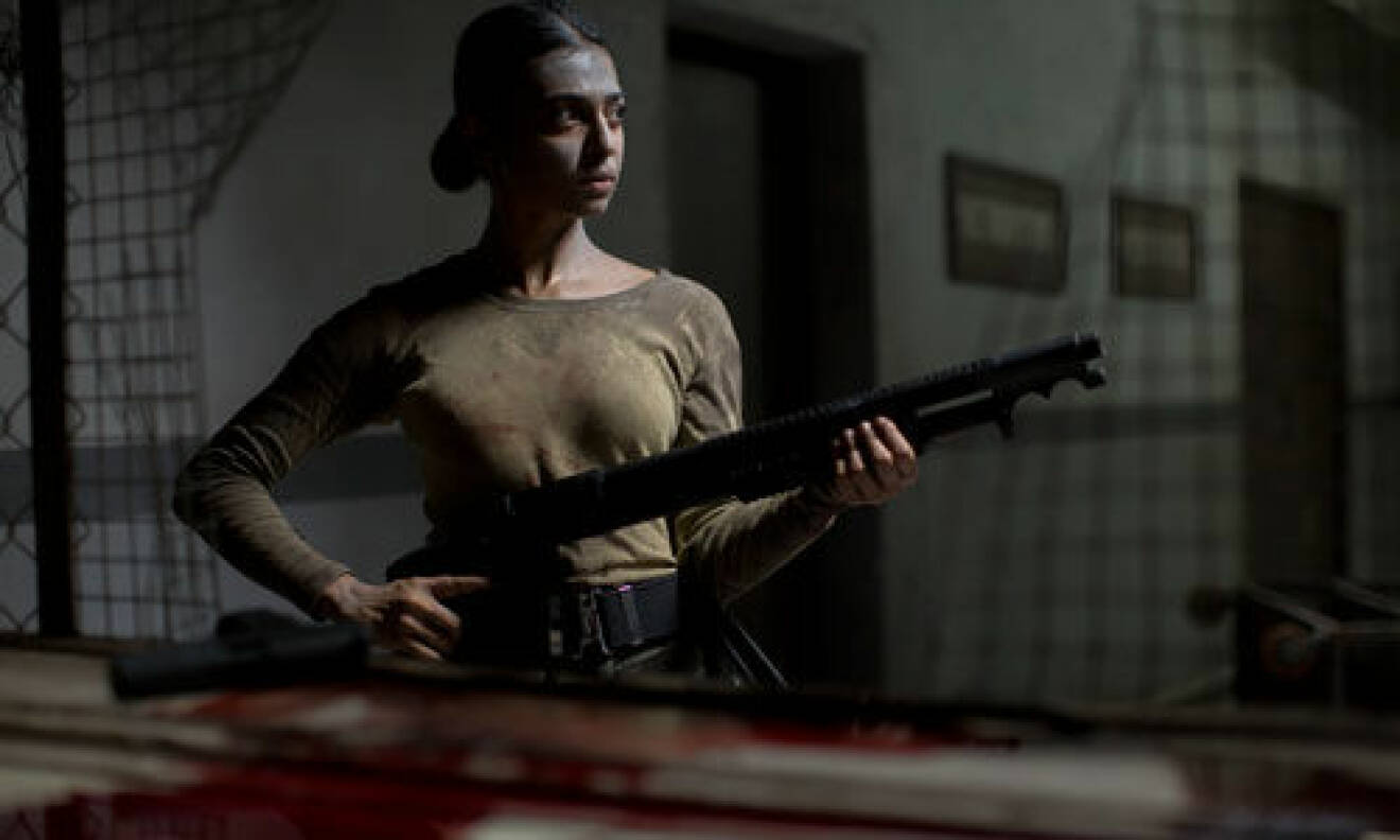 Radhika Apte spelar förhörsledaren Nida i tv-serien Ghoul. Här håller hon i ett vapen.