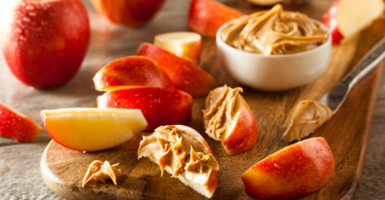 Äppelklyftor doppade i krämigt jordnötssmör botar effektivt sötsuget. 