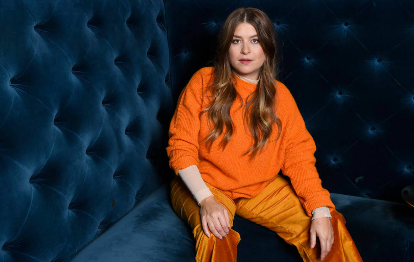 Linnea Henriksson i orange outfit när hon ger intervjuer för "Så mycket bättre".