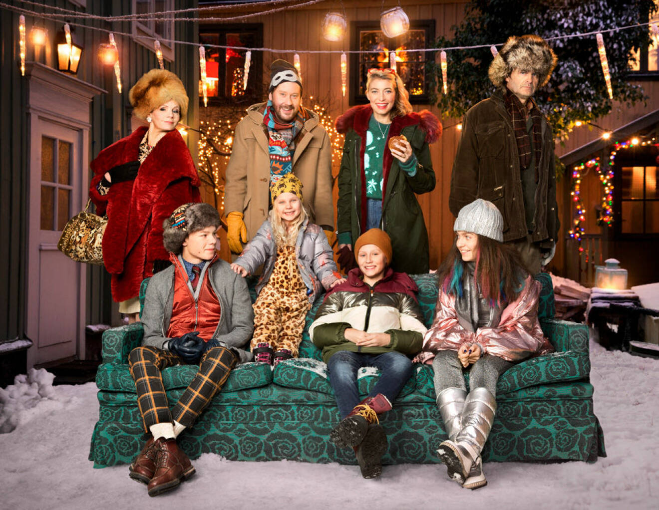 Skådespelarna som är med i årets julkalender, Storm på Lugna gatan, sitter i en soffa i snön.
