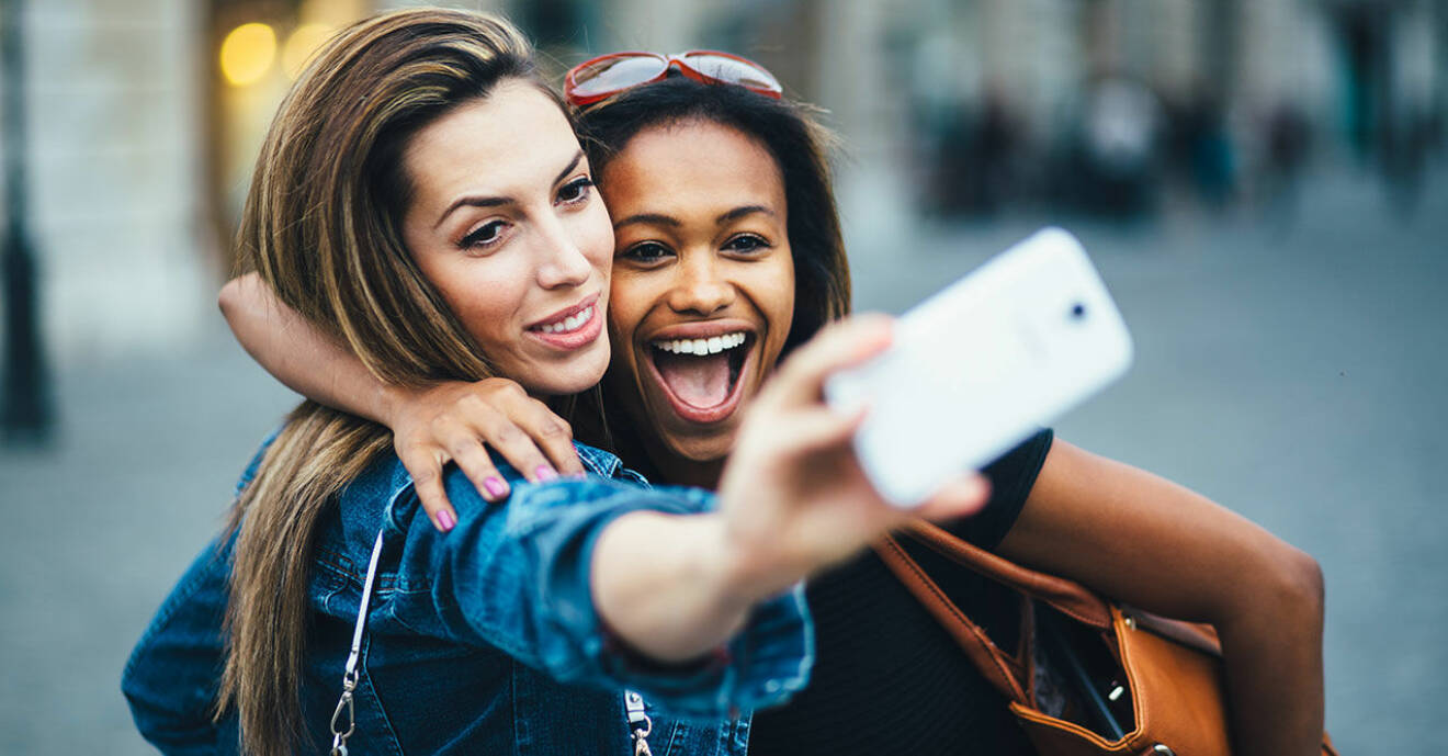 Två kvinnor poserar när de tar en selfie