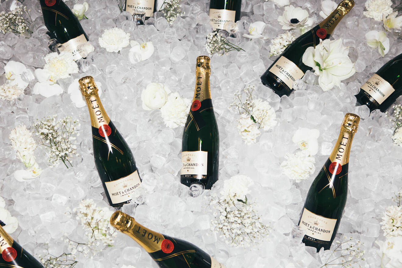 Champagne från Moet ligger på is och blommor.