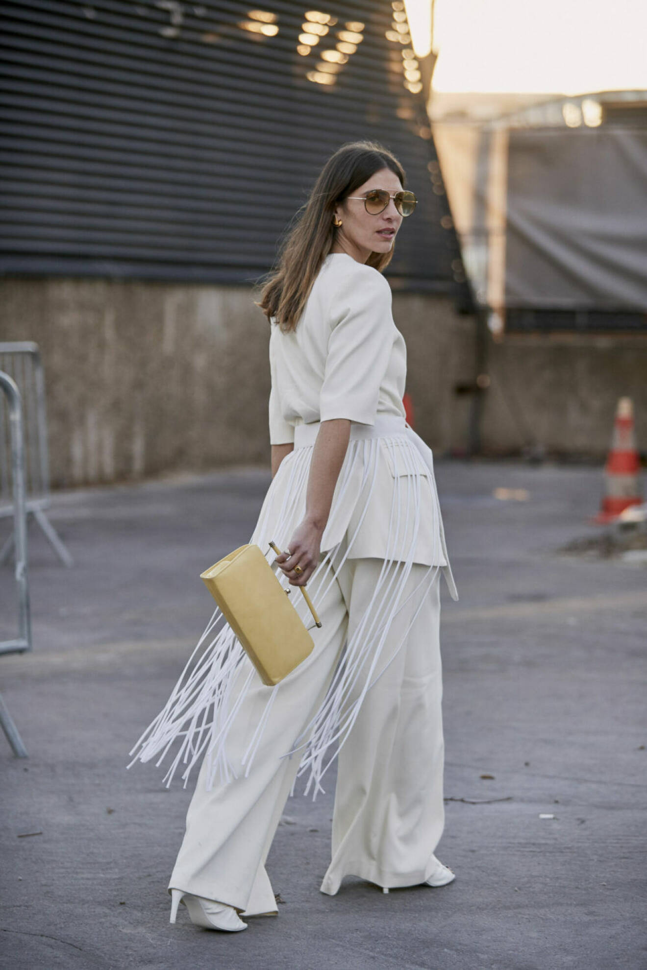 Streetstyle Paris FW, kvinna i vit outfit med gul väska.