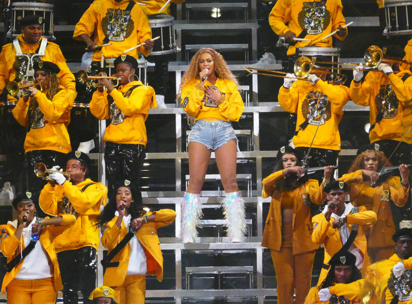 Beyoncé i gul tjocktröja på scen.