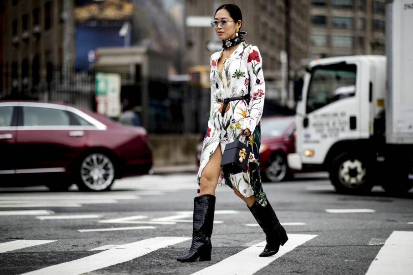Spotted! Aimee Song bär svarta cowboy-boots tillsammans med en mönstrad klänning på New York Fashion Week streetstyle. Foto: Imaxtree. 