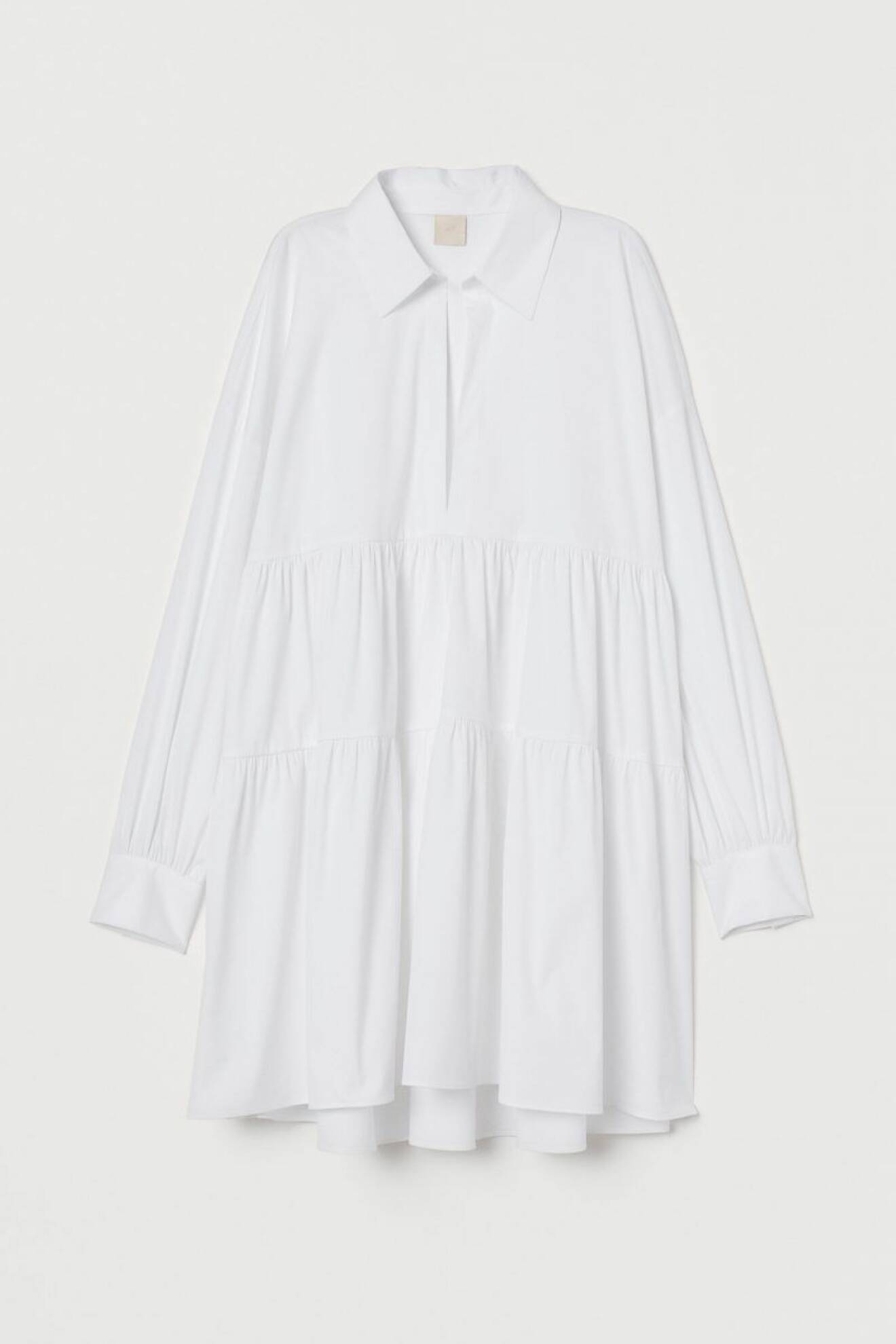 Vit miniklänning med krage, djup v-ringning och volang för att skapa volym, från H&M. Shoppa klänningen här!