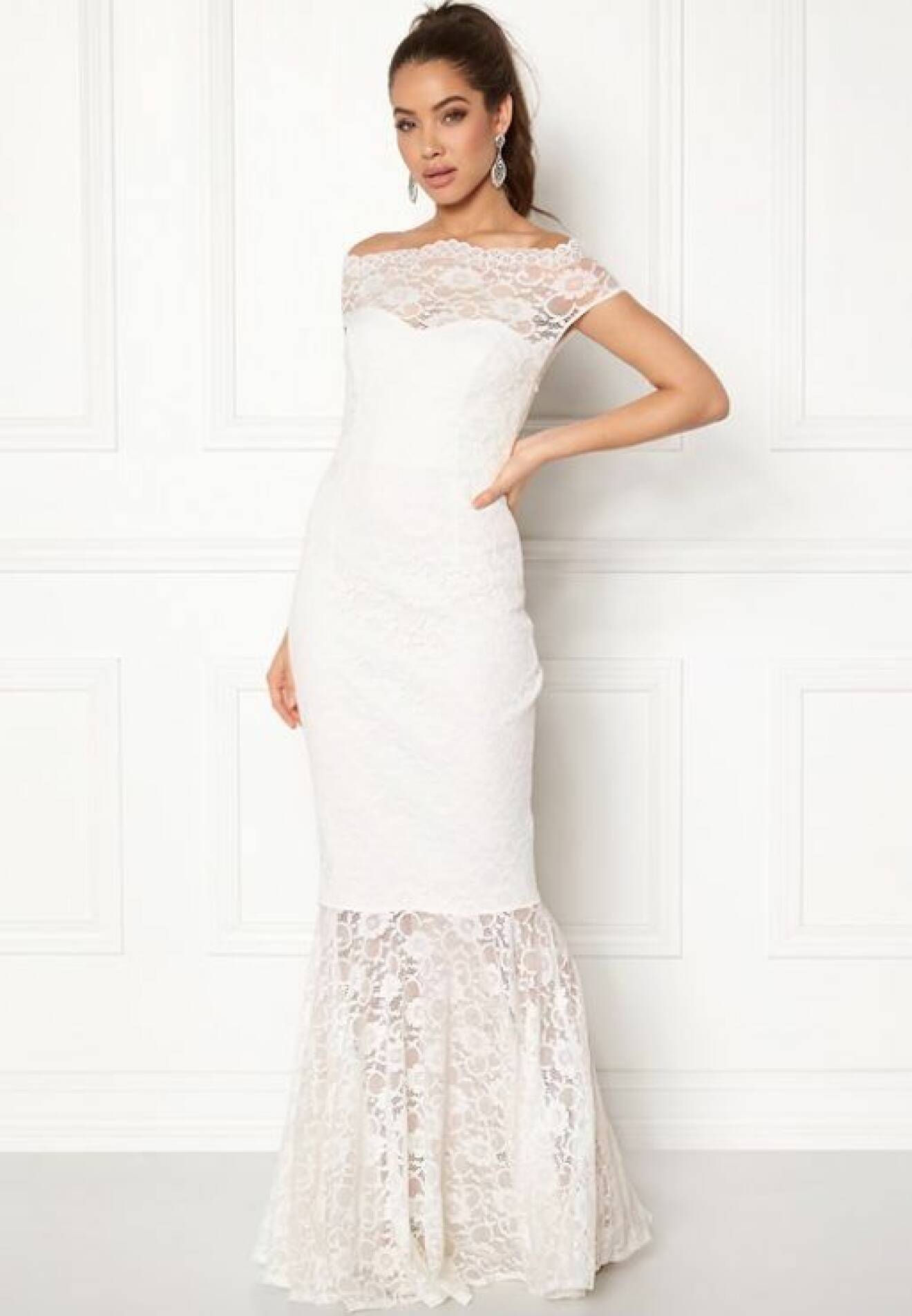 En bild på en vit klänning i fishtailmodell med spetsdetaljer från Goddiva.