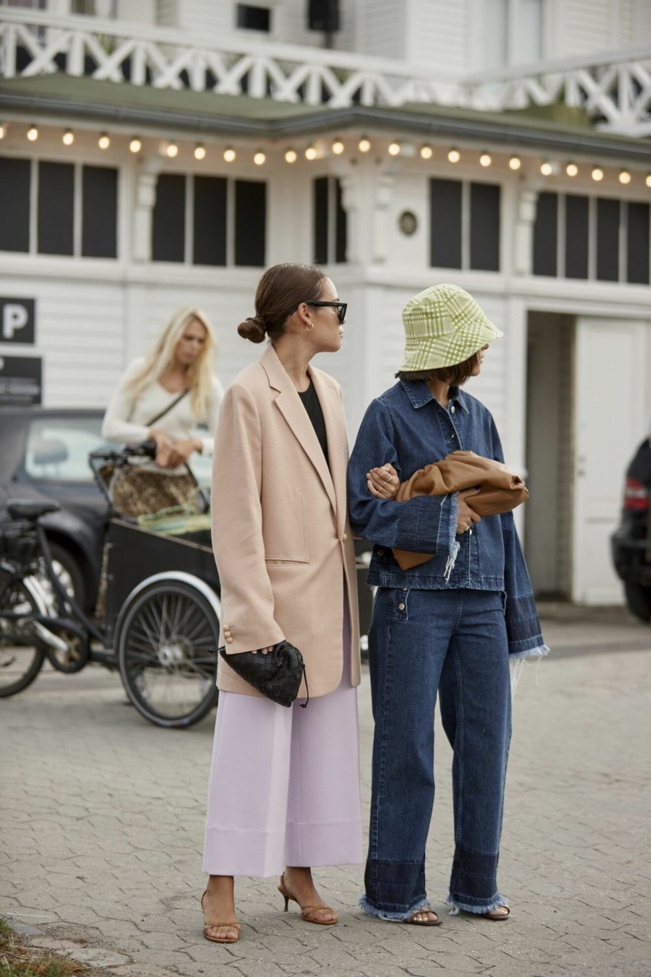 Streetstyle SS20 i Köpenhamn under Fashion Week. Kvinna i oversized kostym och kvinna i jeans från topp till tå.