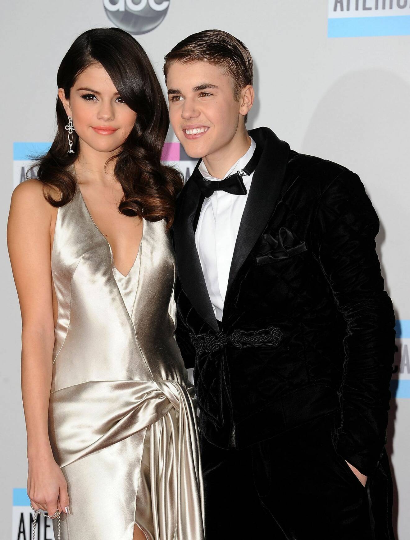 Justin Bieber i svart kostym och Selena Gomez i guldig klänning