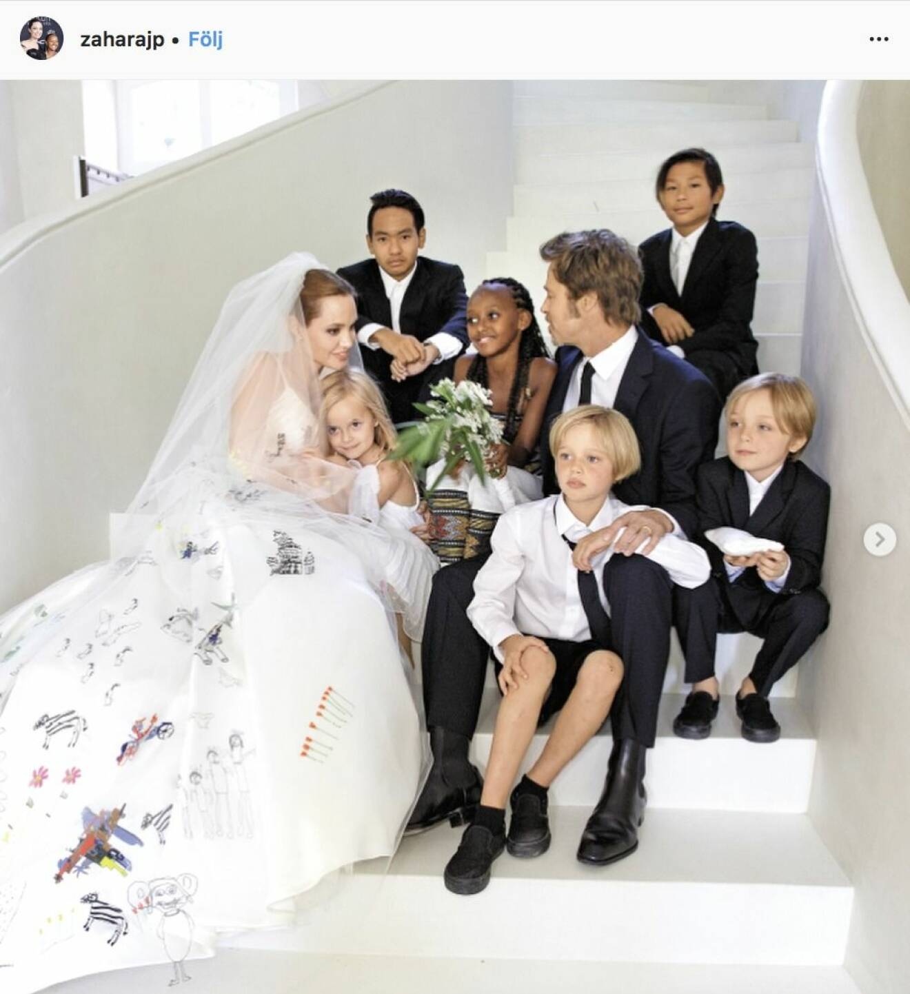 Brad Pitt och Angelina Jolie sitter i en vit trapp med alla sina barn och Angelina Jolie har en brudklänning på sig