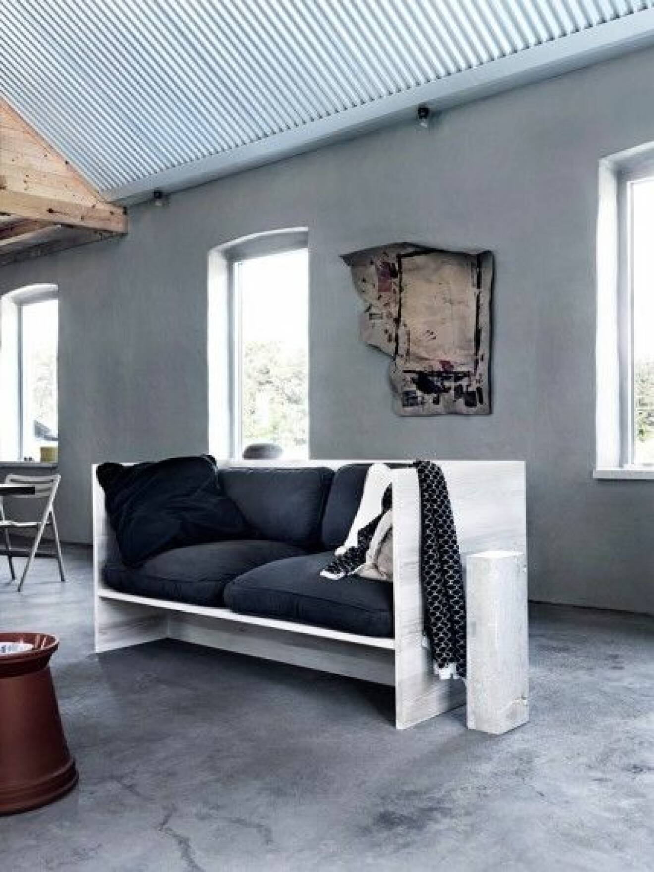 vardagsrum-grått-kalksten-industriellt-bygg-en-soffa-foto-jonas-ingerstedt