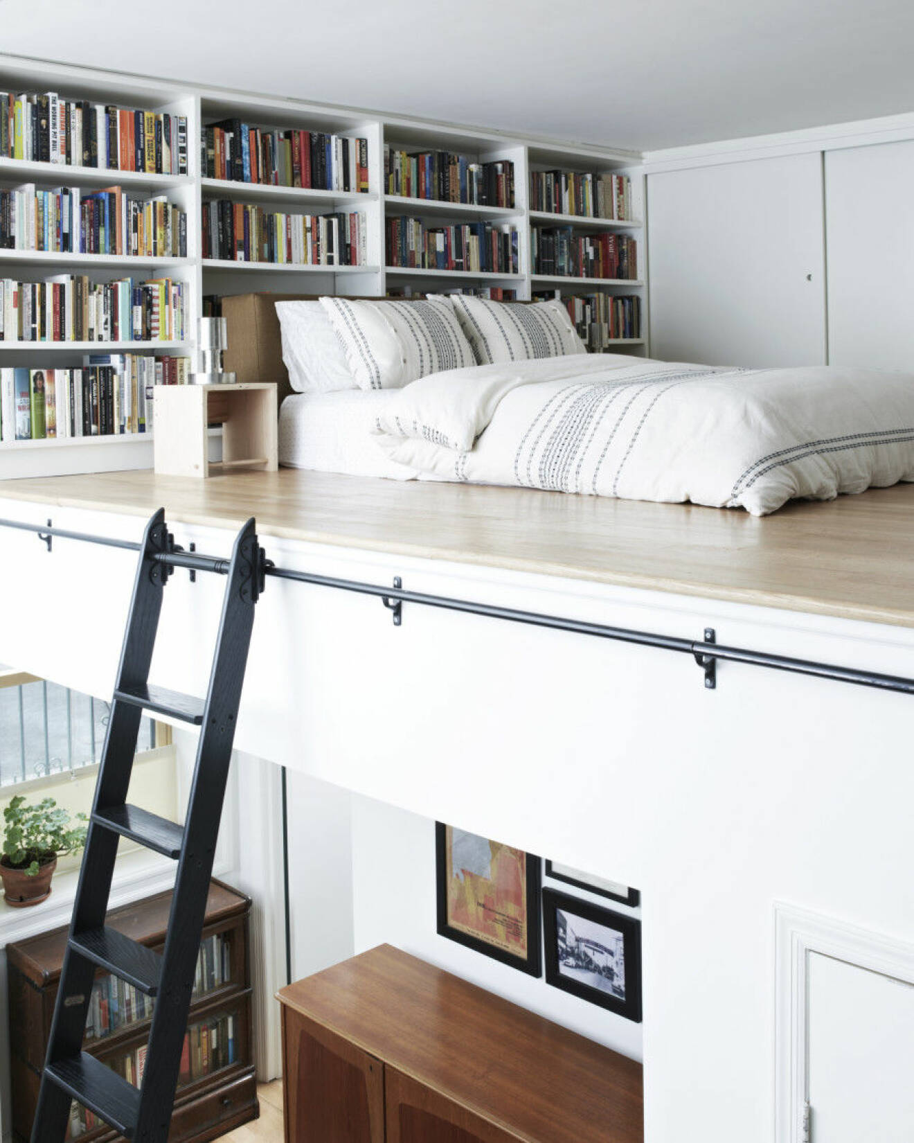 Ett loft med plats för både säng och platsbyggda bokhyllor
