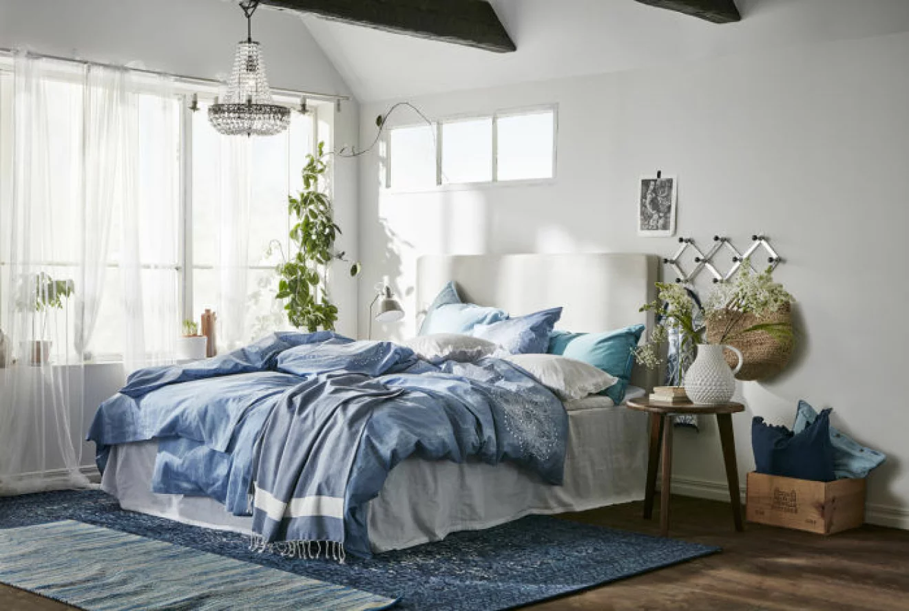 Sovrum med blått som accentfärg på mattor och sängkläder