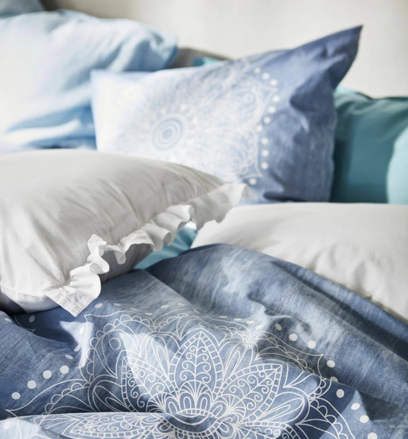 Detaljbild på sängkläder i blåa toner