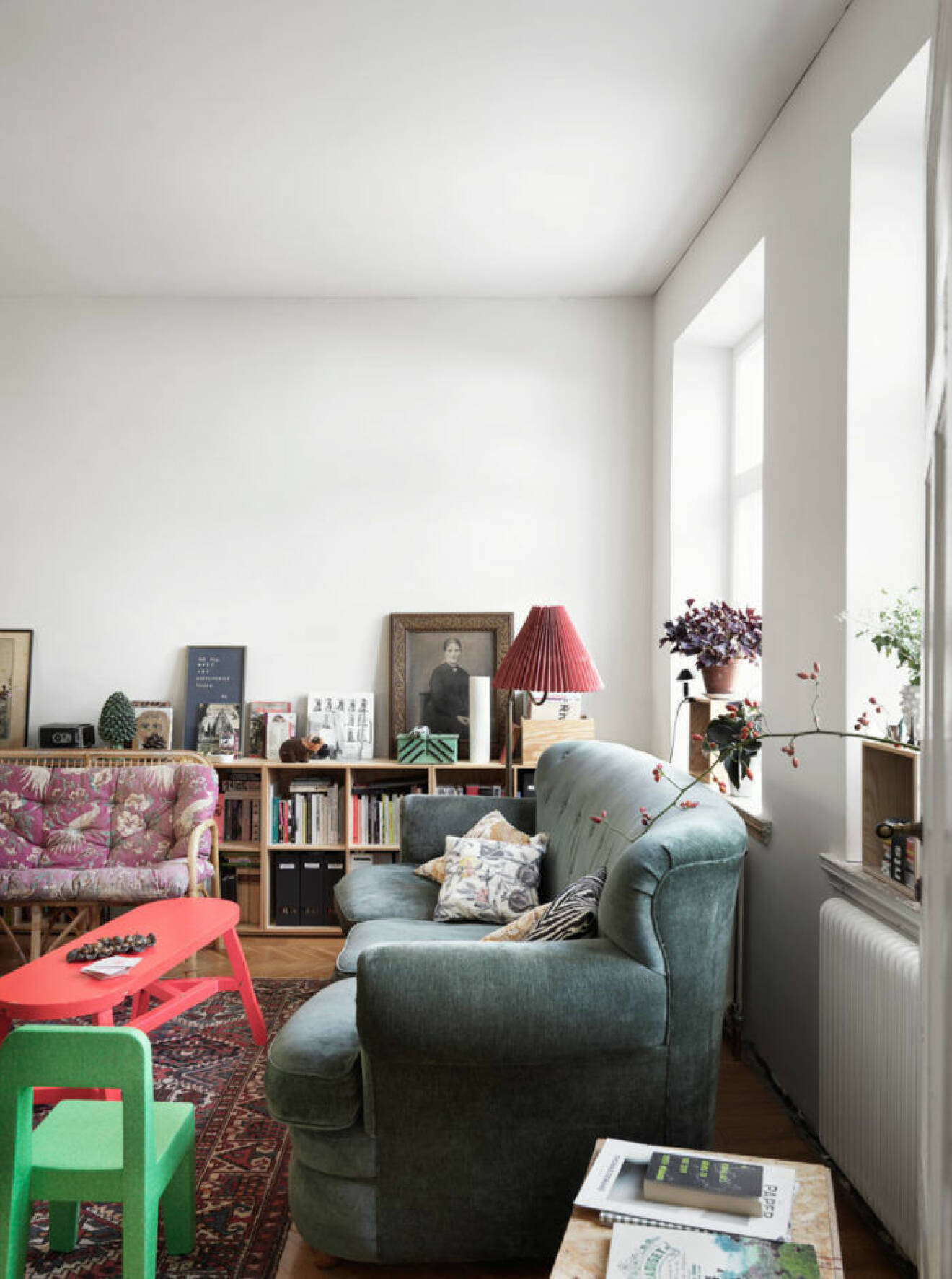 Vitmålat vardagsrum med färgglada möbler