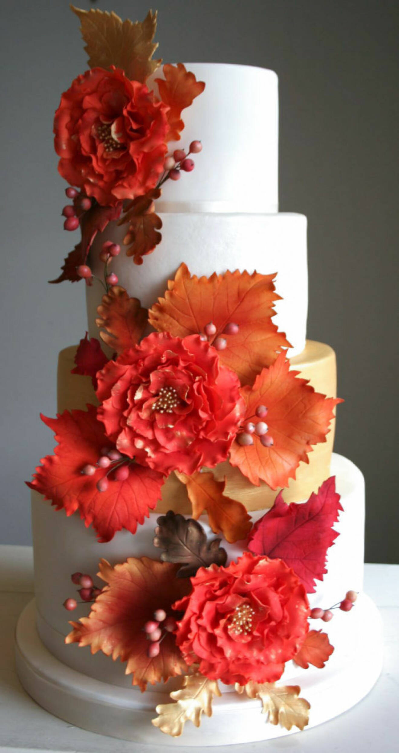 En enkel vit tårta med färgsprakande rött som dekoration