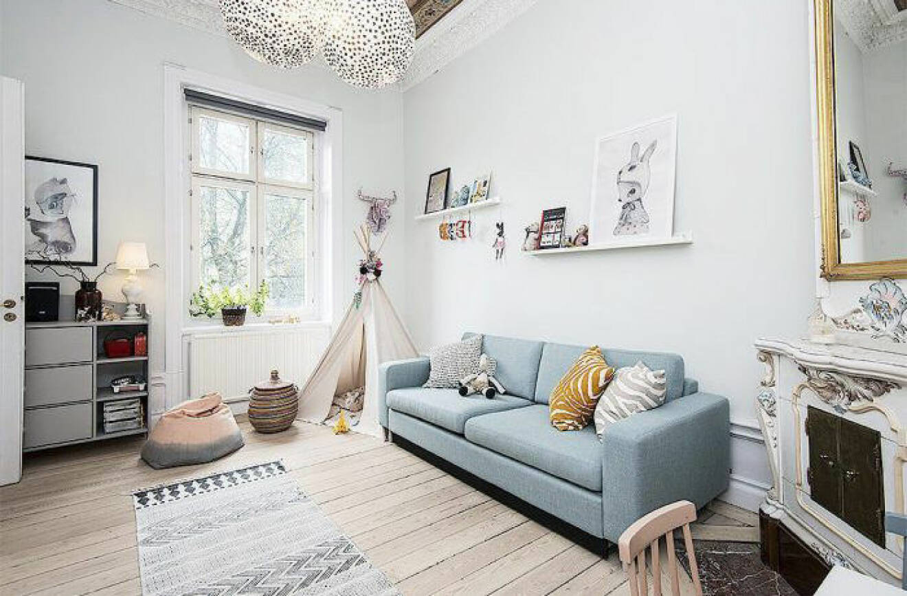 Ljusblå soffa med mönstrade textilier