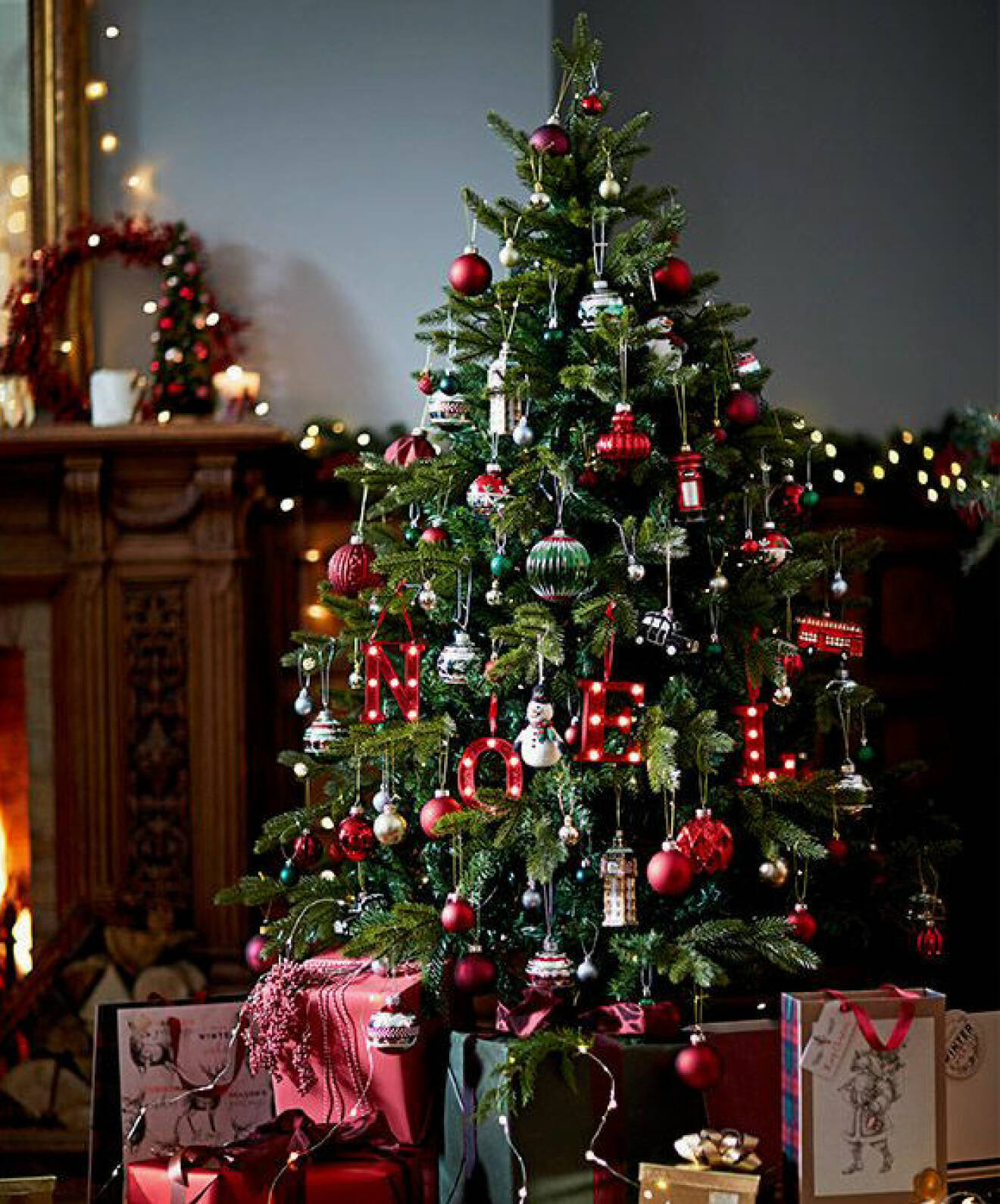 Klädd julgran, röda dekorationer. 